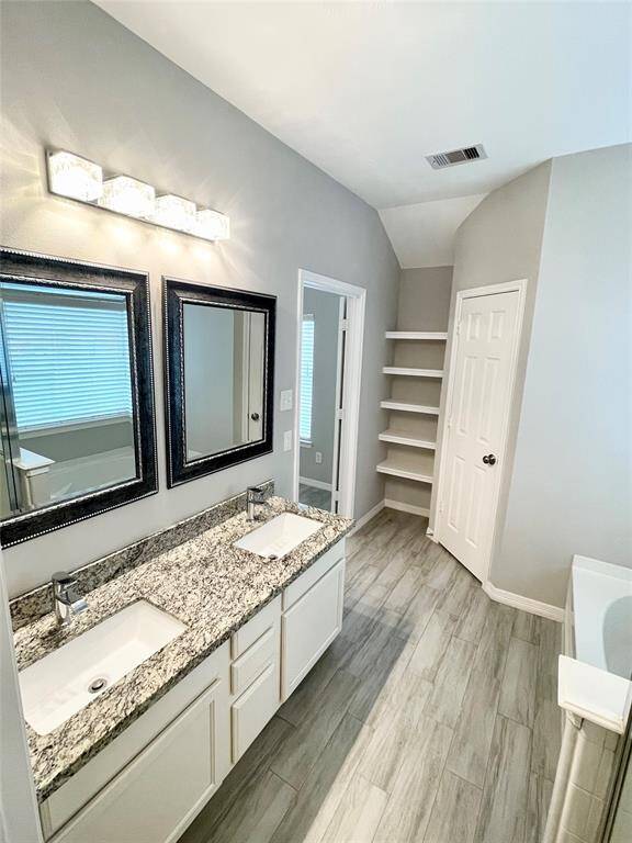 Master bath with double sinks and granite countertops, separate shower and tub.