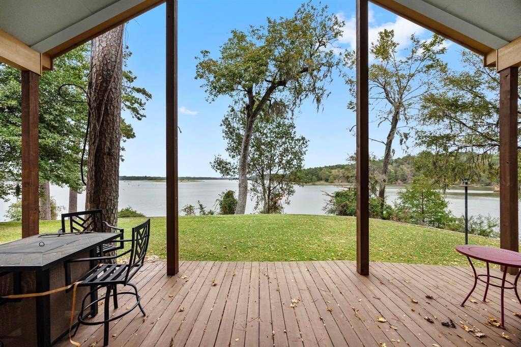 From the back double doors outside the family room, enjoy an unobstructed waterfront view where serene vistas stretch across the water to the peaceful Camp Olympia, Whispering Pines Golf Course, and untouched woodlands. This picturesque scene offers a sense of privacy and tranquility, making it the perfect backdrop for everyday living.