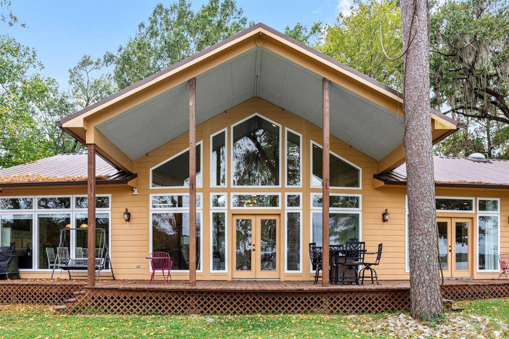 A spacious, grand back porch offers breathtaking views of the tranquil waterfront, perfect for enjoying the sunrise or relaxing and enjoying shade in the afternoon.