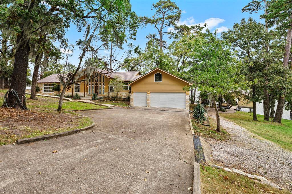 Front of home. Note the large 3-car garage, gravel path leading down to the boathouse (right side).