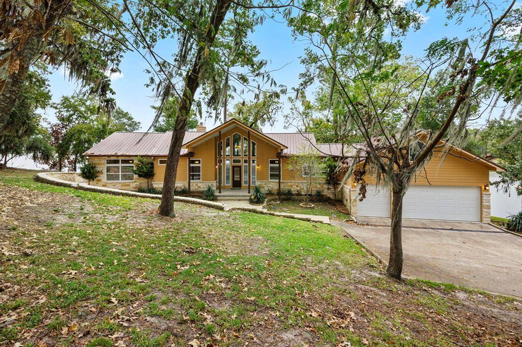 Front of home.  Custom built property on 2-acre peninsula.  Features 3 bedrooms (of which 2 are Primary Bedrooms), 3.5 bathrooms, and many thoughtful upgrades and accents throughout.