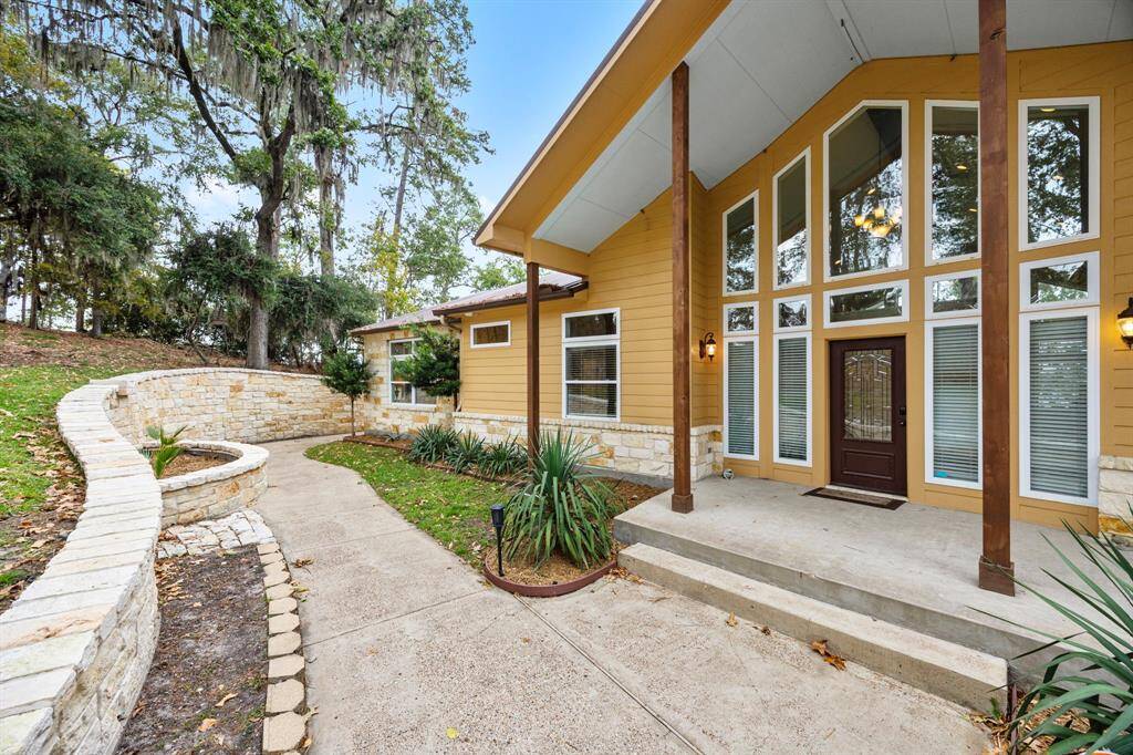 Grand front entrance to home.  Half-circle flower bed along stone wall can also be turned into working Koi Pond.