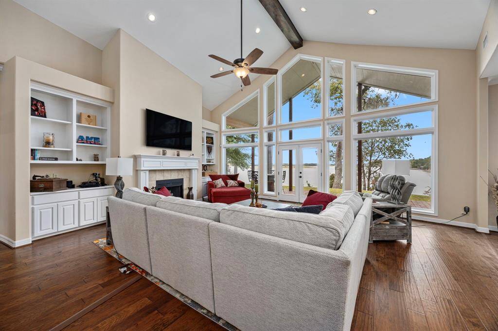 The family room features high ceilings, a cozy fireplace, and built-in bookshelves with cabinets, combining warmth and elegance as it opens toward the heart of the home.