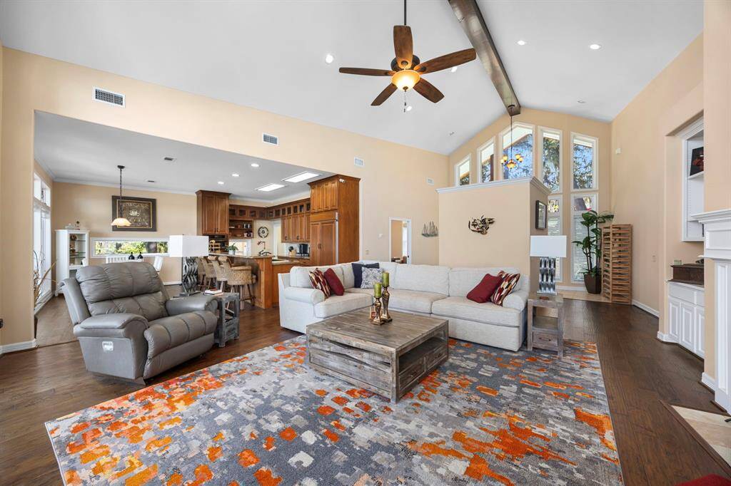 The family room, with its impressive high ceilings, seamlessly flows into the open-concept kitchen and dining area, creating a spacious and inviting atmosphere. This thoughtful layout enhances connectivity, perfect for both everyday living and entertaining guests.