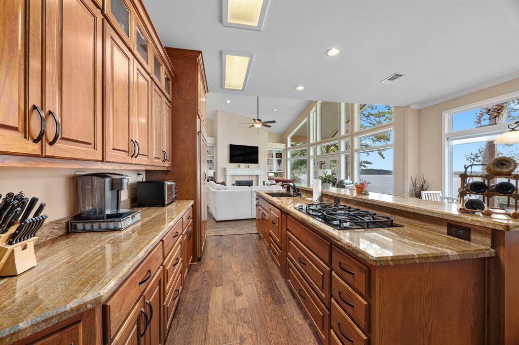 The kitchen seamlessly flows into the open-concept dining area and family room, creating an inviting space perfect for entertaining and family gatherings. A stunning wall of windows offers captivating views of the waterfront, bringing natural light and the beauty of Lake Livingston right into the heart of the home.
