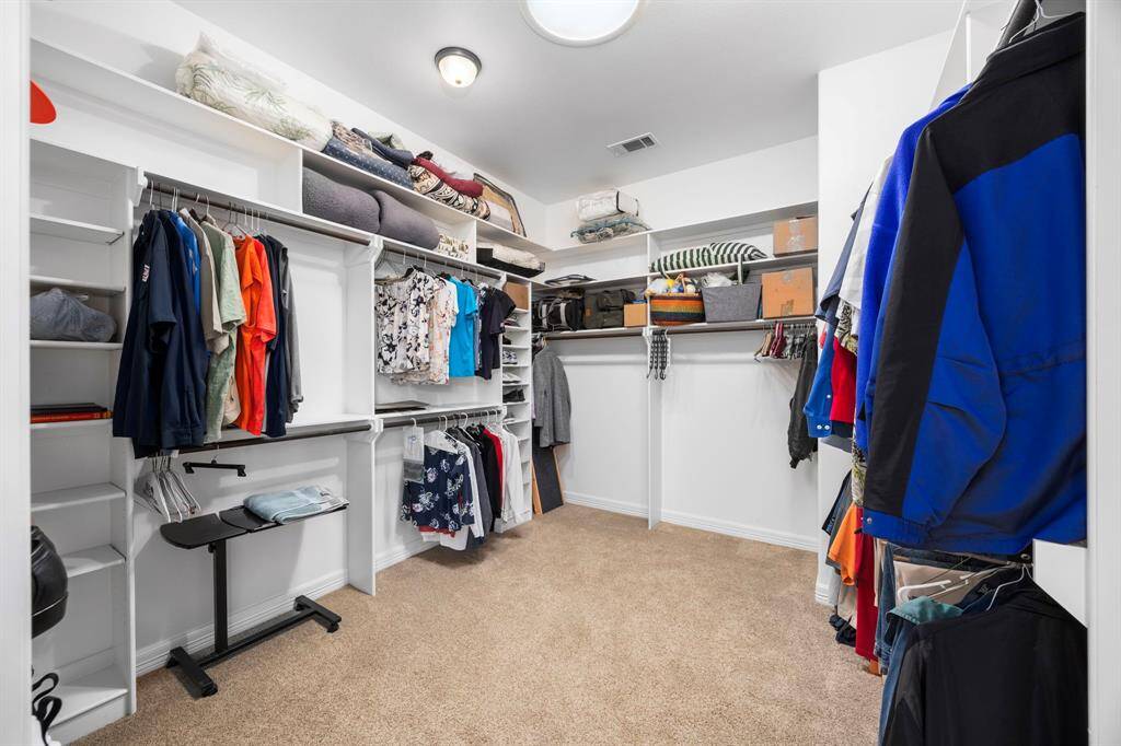 The large walk-in primary bedroom closet offers ample space for apparel and personal items, featuring a Skylight that fills the room with natural light, making it both functional and inviting.
