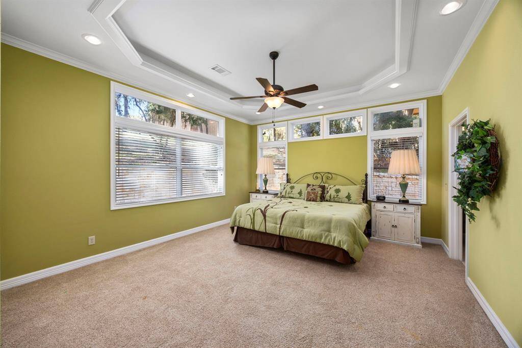 Primary Bedroom #2.  The second primary bedroom offers a tray ceiling with added lighting, creating a bright and inviting atmosphere, and includes a full en-suite bathroom equipped with a handicap-enabled walk-in shower for enhanced accessibility and comfort.