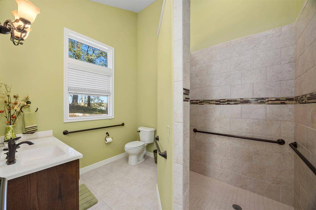 Primary Bedroom #2.  Full en-suite bathroom that is handicap-enabled with handrails and wide opening in the walk-in shower.