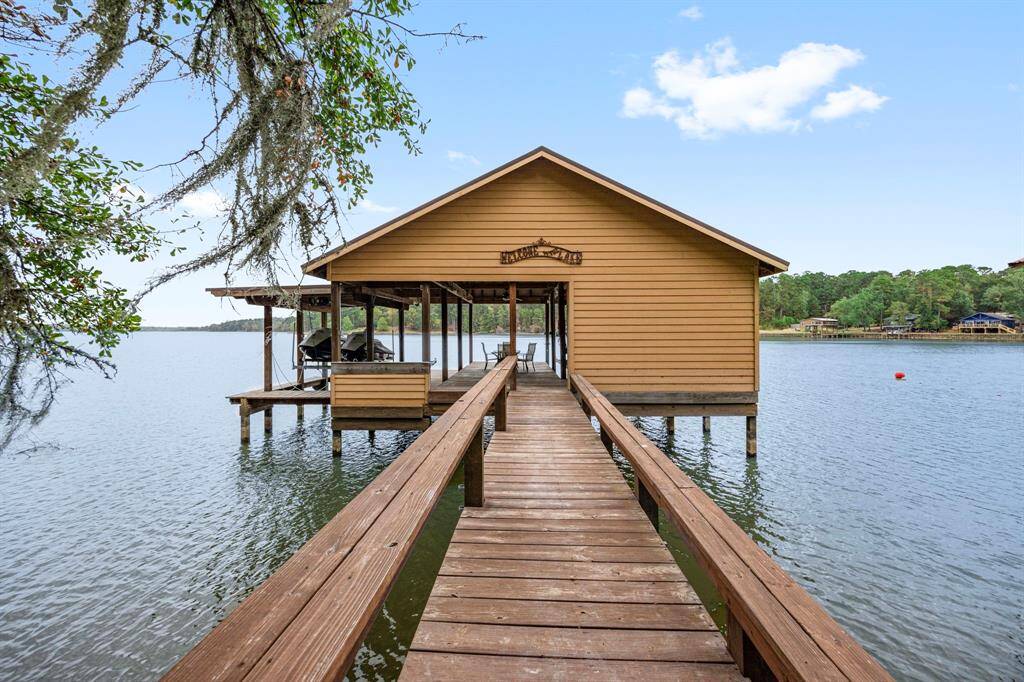 The boathouse, located on deep water, is built for versatility, featuring two boat slips (one converted for extra floor space), upgraded lifts, and offers easy access for fishing, boating, or relaxing on the lake.