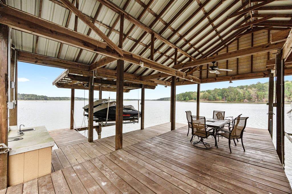 The boathouse, located on deep water, is built for versatility, featuring two boat slips (one converted for extra floor space) and offers easy access for fishing, boating, or relaxing on the lake.  Note the table on the left of the photo - it is sturdy and practical, equipped with a sink, making it the perfect space for de-boning fish with ease and keeping the area clean during the process.