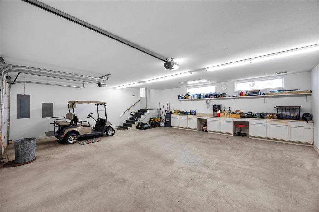The 3-car garage offers abundant space for parking, a large workbench area with ample cabinet space for storage, and a floored attic for even more storage space.  Note - Spider-B-Gone pest control system in center of photo and the end of the countertop.