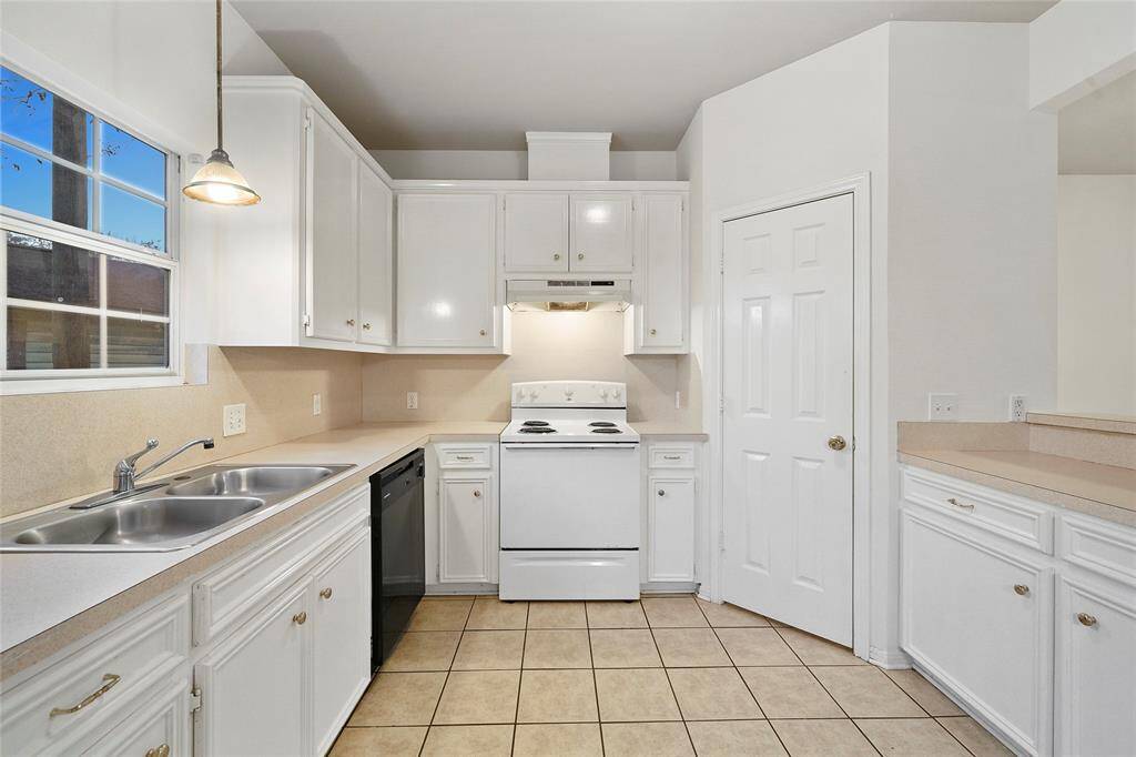Kitchen - view 1 - this large kitchen features tons of custom site-built cabinetry, several storage drawers and a corner pantry.  The kitchen sink is illuminated by a drop pendant light, natural light enters from the wide window just above the sink - this home has tons of natural light!