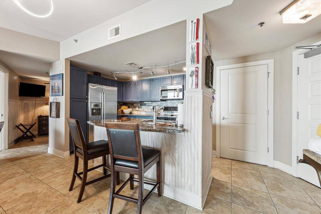 The stylish kitchen boasts sleek stainless steel appliances and stunning granite countertops.