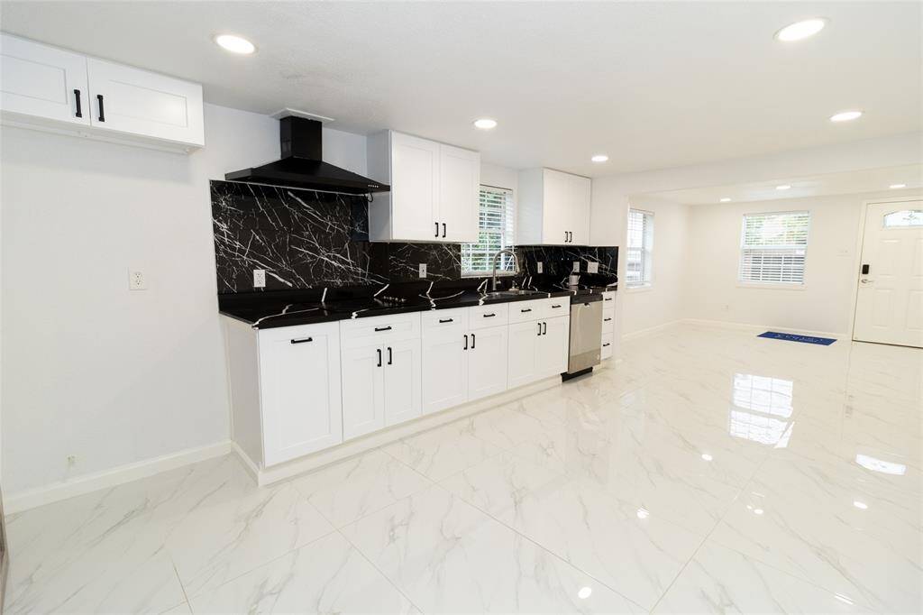The kitchen features stainless steel appliances and neutral-toned cabinetry.