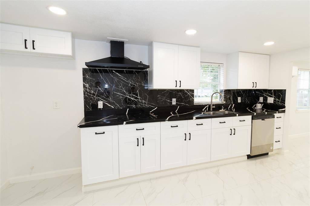 The kitchen features stainless steel appliances and neutral-toned cabinetry.