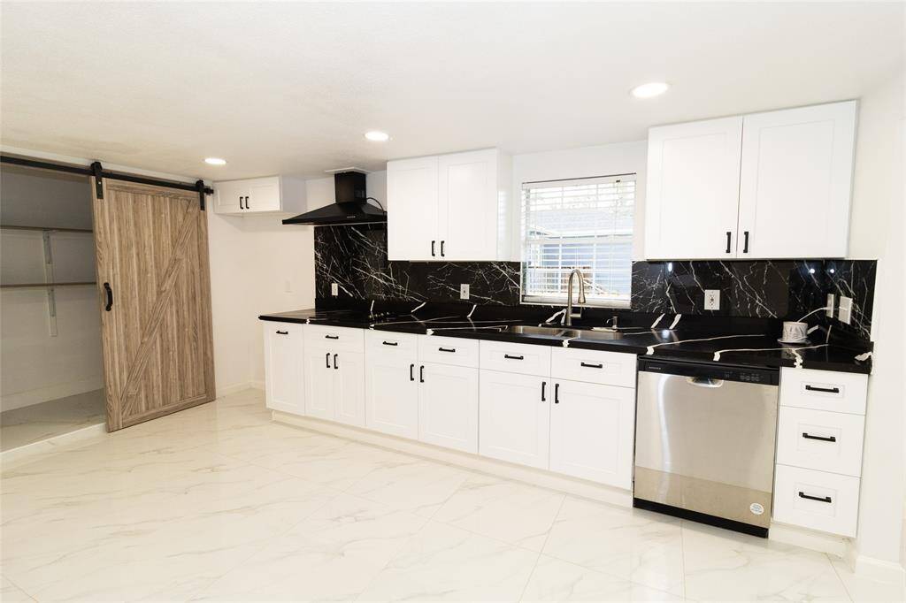 The kitchen features stainless steel appliances and neutral-toned cabinetry.