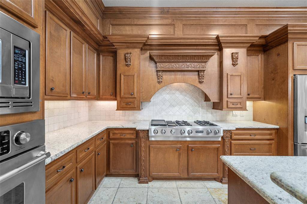 Your spacious kitchen offers decorative molding, ample counter space, an elegant tiled backsplash and gas cooktop with griddle.