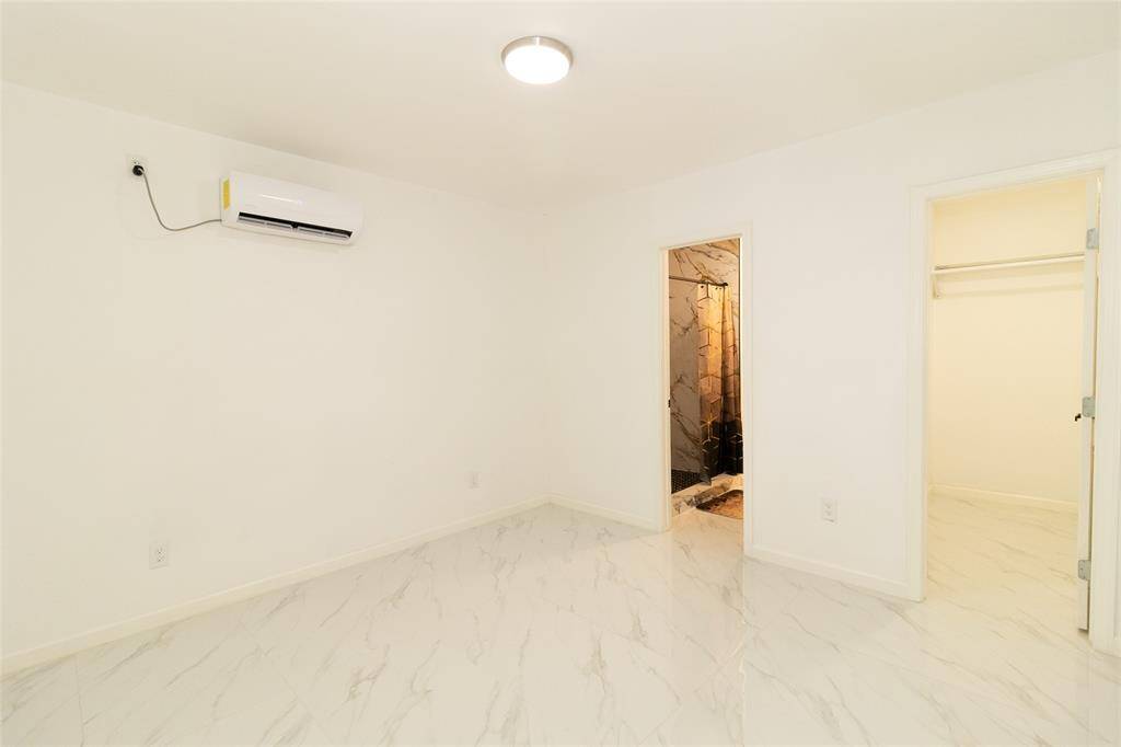 This is a clean and two doors, one leading to a closet and the other to a bathroom with a visible shower.