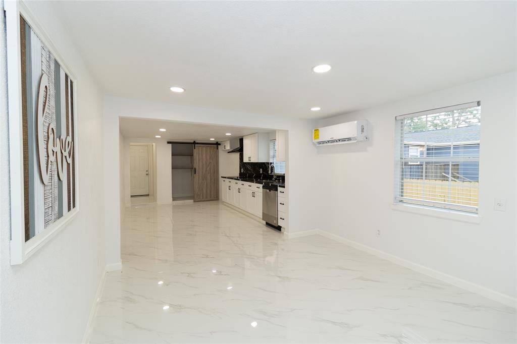 The kitchen features stainless steel appliances and neutral-toned cabinetry.