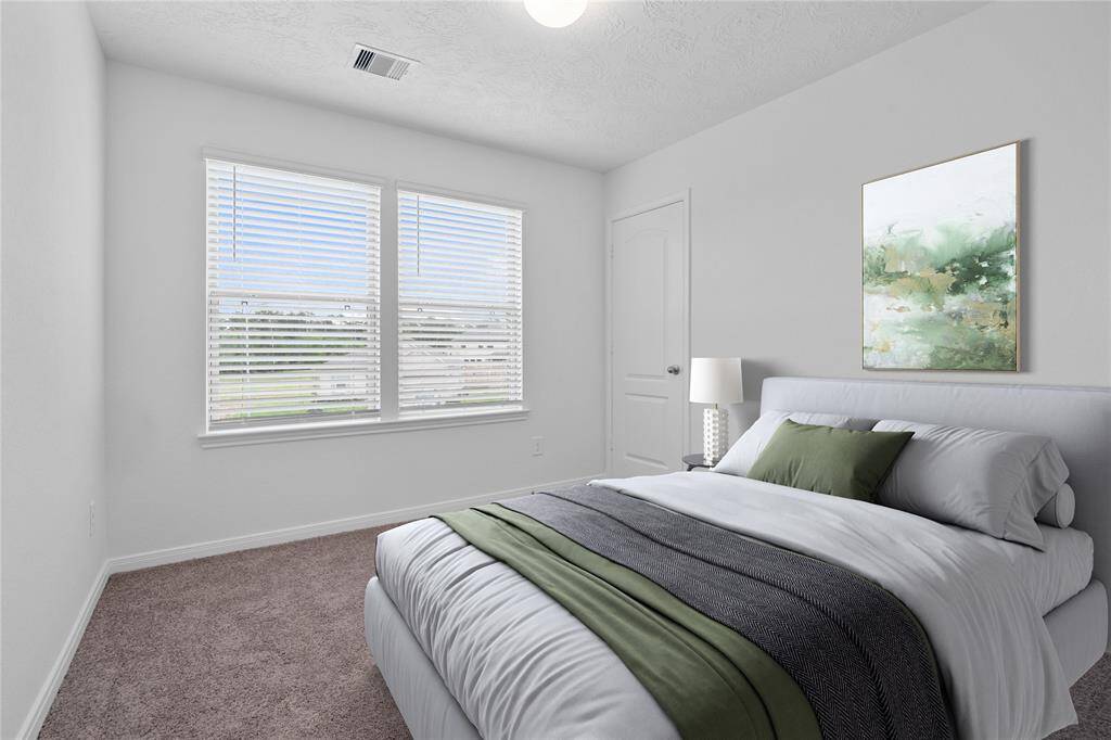 Secondary bedroom features plush carpet, neutral paint, lighting, large windows with privacy blinds, and ample sized closet space.