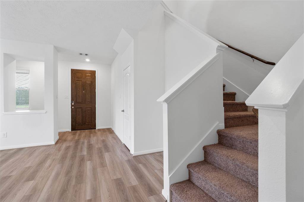 Welcome to your new home at 25635 White Vortex Drive. You are greeted with this beautiful entryway featuring vinyl plank flooring and custom paint.