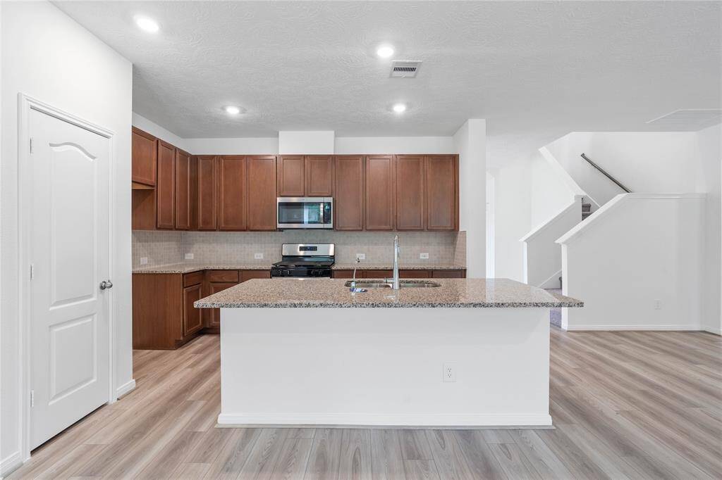 Another view of this spacious kitchen and view of the staircase that leads to the secondary bedrooms on the second floor!