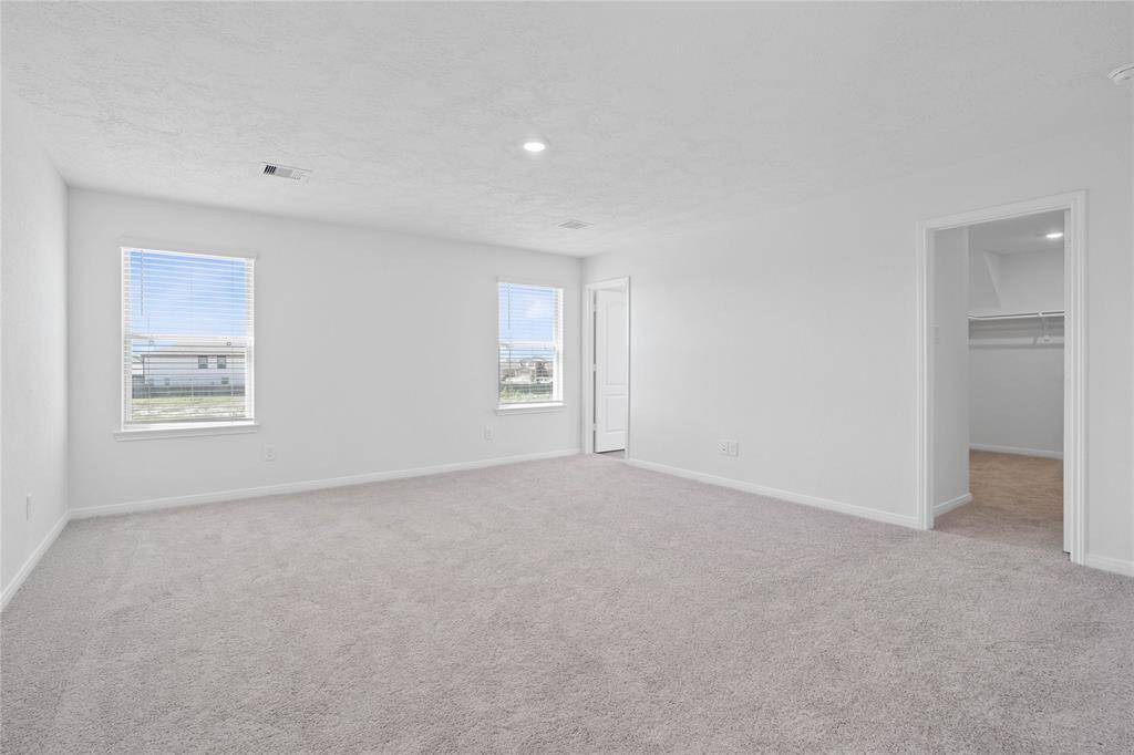 What a wonderful place to come home to, this stunning, spacious primary suite greets you with gorgeous plush carpet, custom paint, high ceiling, lighting, walk-in closet, and lovely windows allowing in natural light brightening up this spacious primary bedroom!