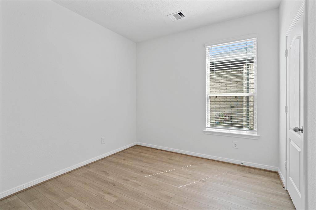 Quietly nestled in the home is the handsome den that can be used as an office, sitting room, or play room. Featuring gorgeous vinyl plank flooring, high ceilings, large window with privacy blinds and neutral paint.