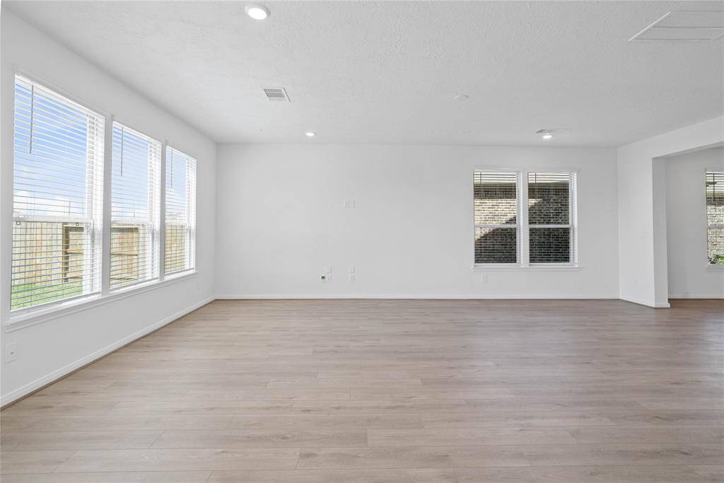 Gather the family and guests together in your lovely family room! Featuring high ceilings, custom paint, gorgeous vinyl plank flooring, and large windows with blinds that provide plenty of natural lighting throughout the day!