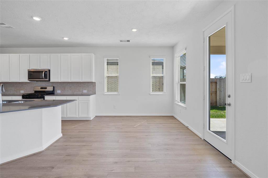 This lovely dining room is perfect for starting the day out on the right foot! This space showcases custom paint, high ceilings with recessed lighting, windows adding to the ample natural light in the kitchen, and vinyl plank flooring!