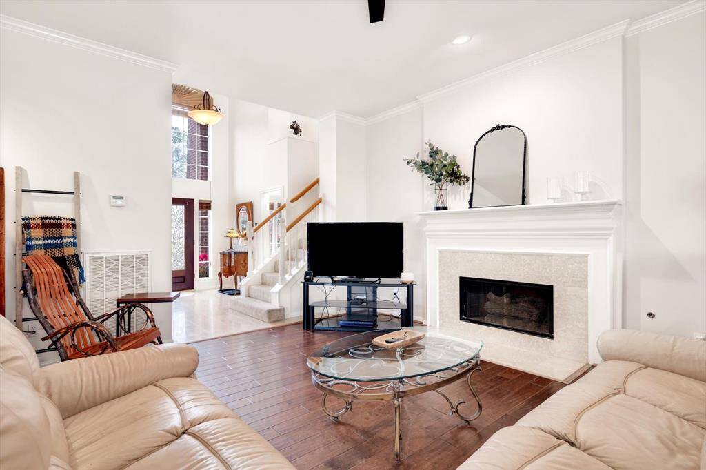 Living room at the heart of the home hosts a fireplace and backyard green view.