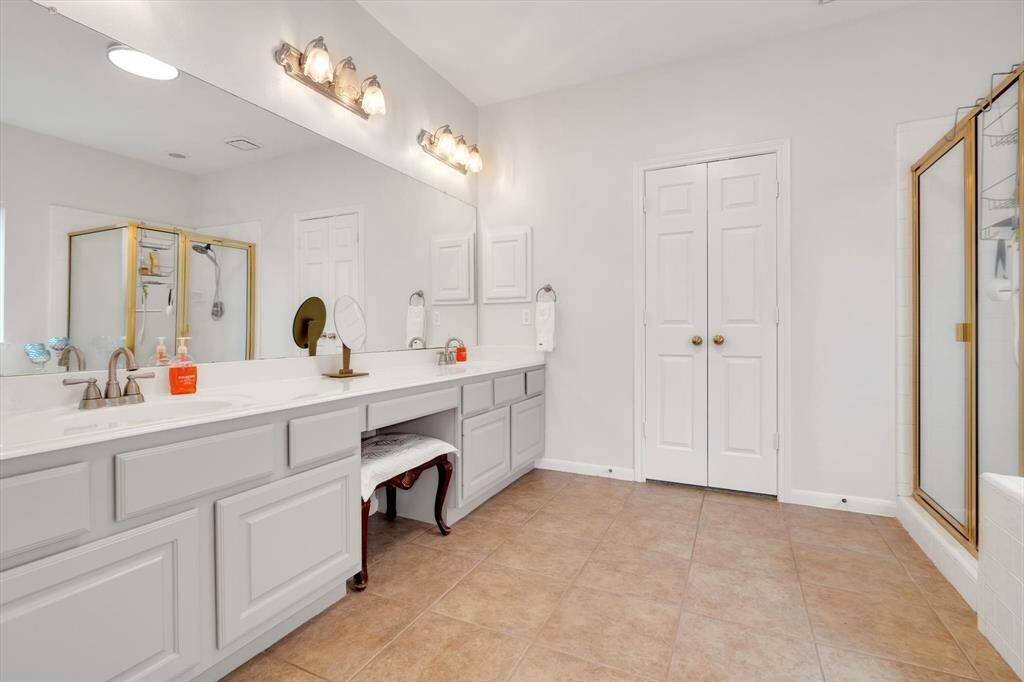 Spacious primary bathroom with elegant fixtures and abundant storage.