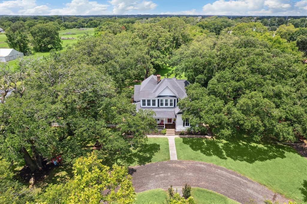 AERIAL SHOT OF THE HOME AND HORSESHOE DRIVEWAY SURROUNDED BY MATURE TREES!
