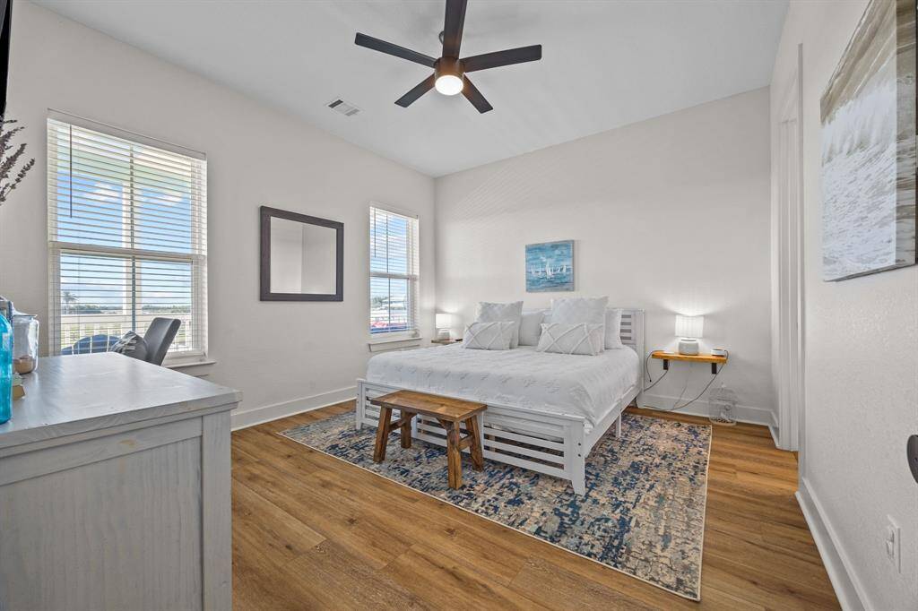 Primary bedroom with tons of natural light and wide plank laminate flooring.