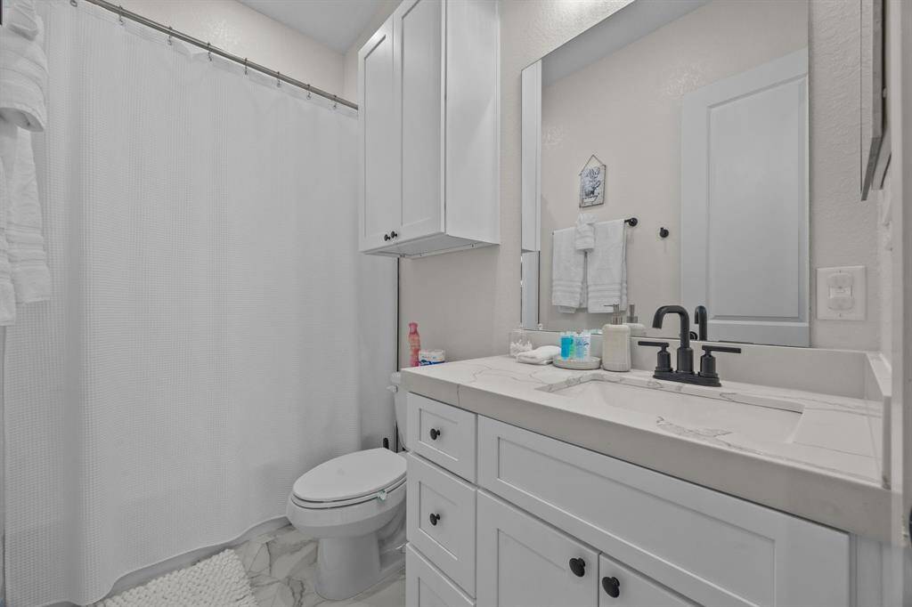Hall bathroom with a tub/shower combo and quartz counter tops.