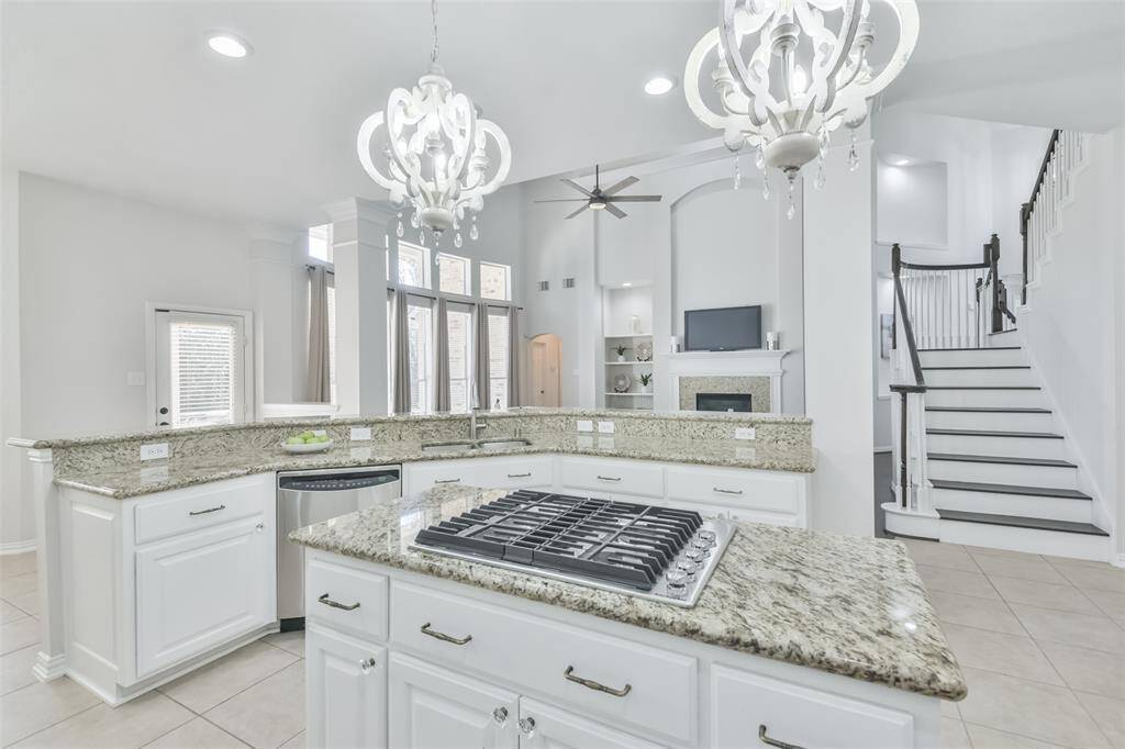 You'll enjoy the 42” cabinets with drawer pulls, stainless steel appliances (GE Profile dishwasher, Kitchenaid 4-burner cooktop, Panasonic microwave, GE Profile oven), two chandeliers over the island with the cooktop, the pantry, and recessed lights.