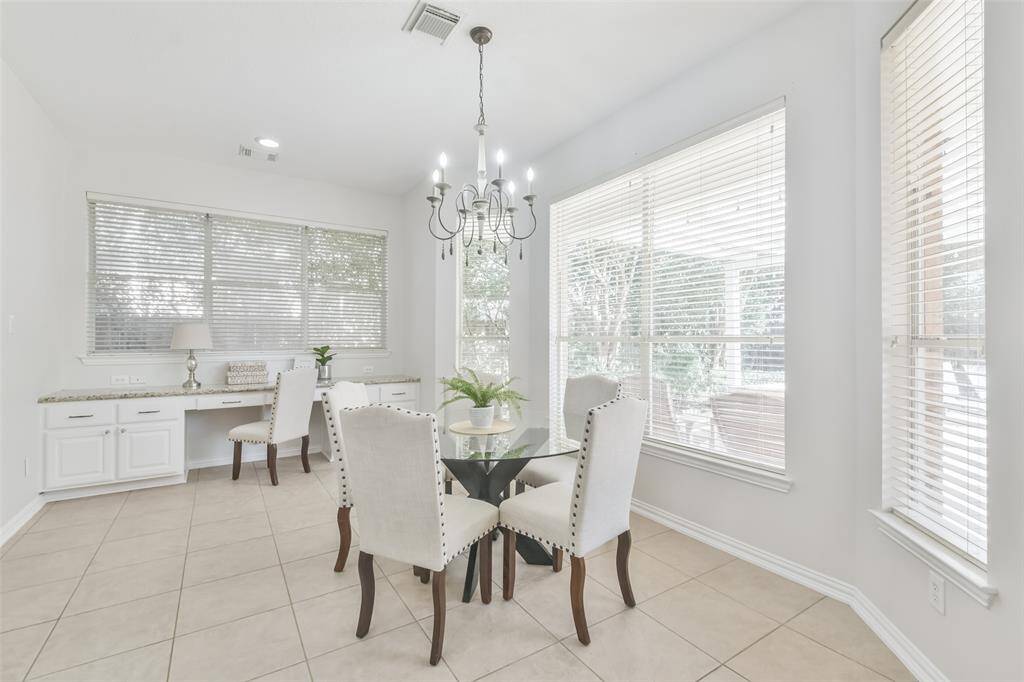 The breakfast room is so spacious and has tile floors and a chandelier.