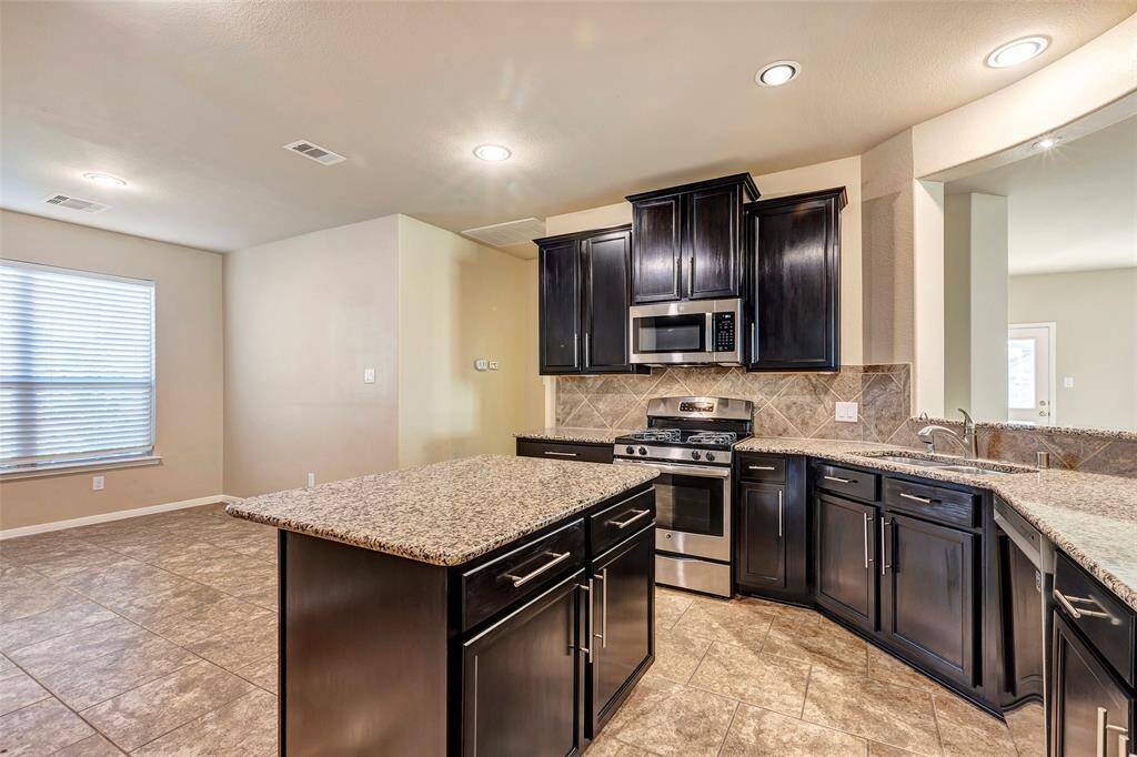An abundance of recessed lights provide ample lighting for the large kitchen and breakfast area. Stainless steele appliance with a recently replaced dishwasher and new microwave.