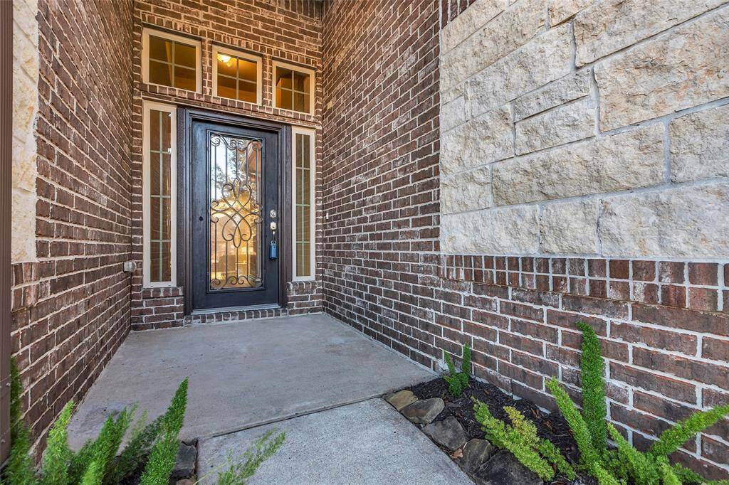 This picturesque entry welcomes you and your guests. Notice the custom glass and iron front door as well as the integrated stone and brick front elevation.