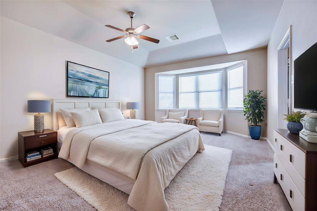 Spacious primary retreat with a bay window extension and high ceiling.