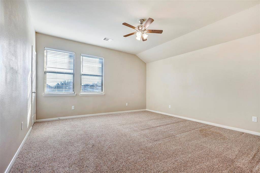The second primary bedroom upstairs is spacious and also has a ceiling fan.