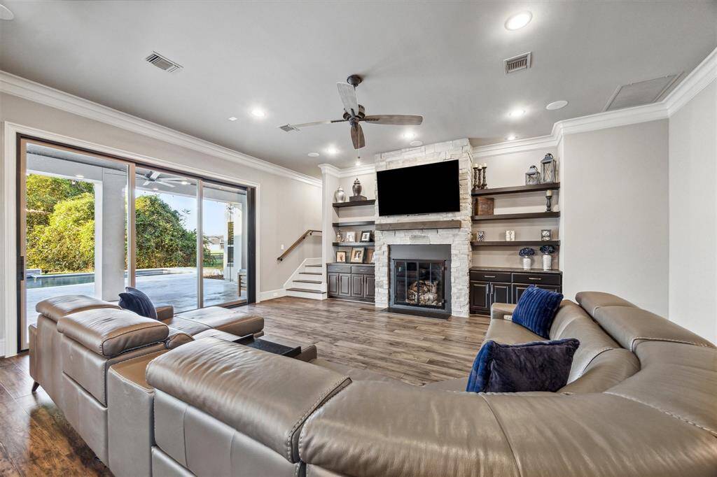 Glass sliding doors offer captivating views of the lush acreage and sparkling pool, bringing the beauty of the outdoors inside.