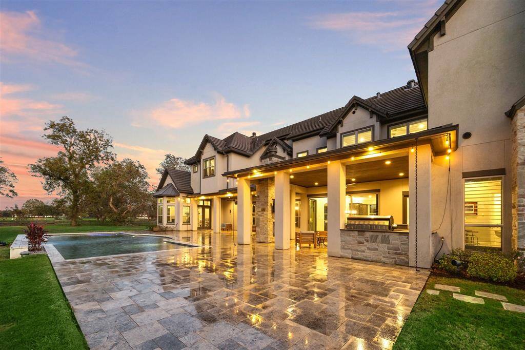 Outdoors, you'll find a resort-style pool, an inviting outdoor kitchen, a cozy fireplace, and endless high-end selections throughout the property.