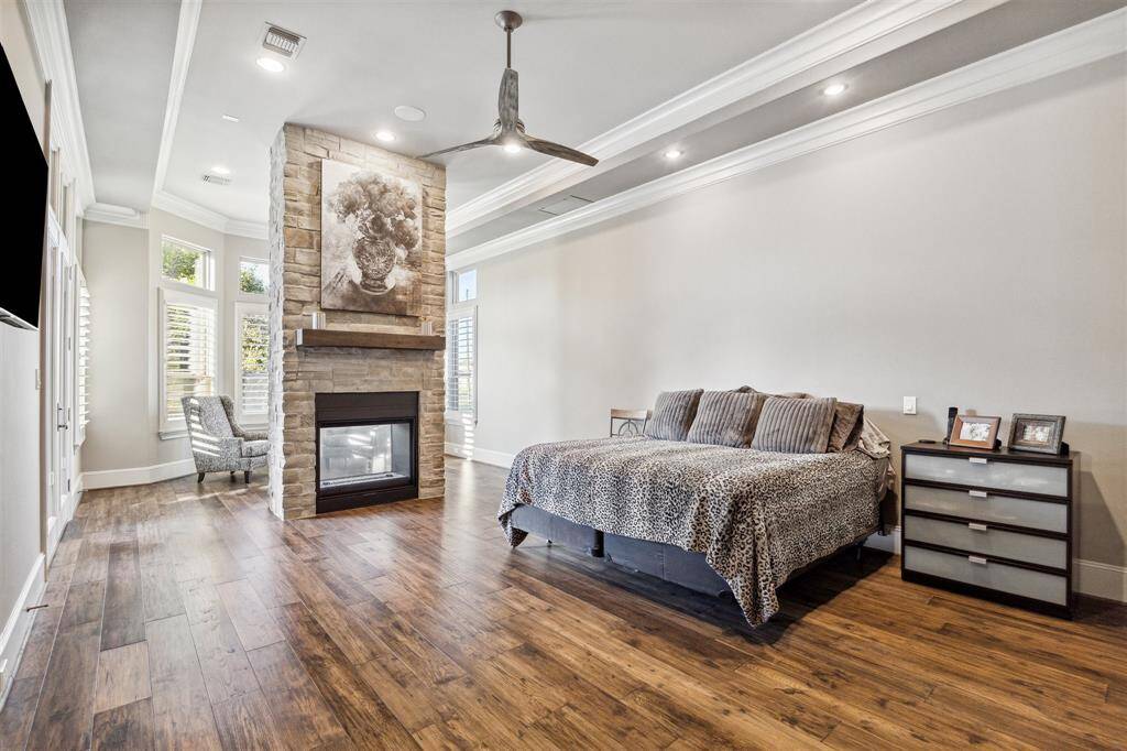 The primary suite is a true retreat, boasting a sitting area overlooking the pool, a cozy fireplace, and an elegant restroom.