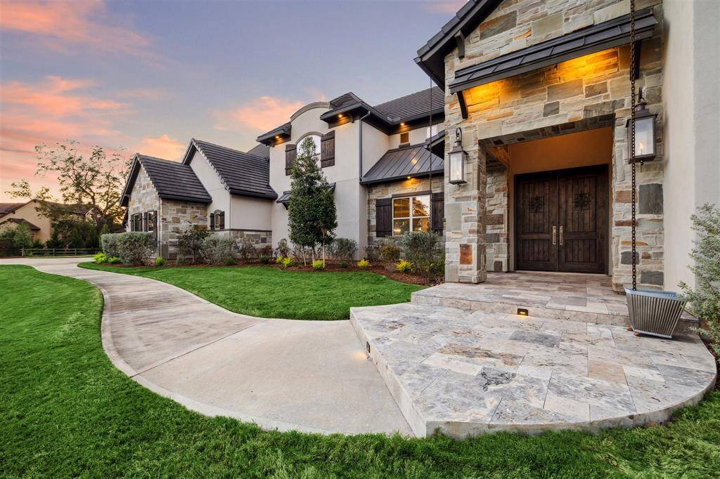 The elegant and extensive walkway greets your guest with double doors and outdoor lighting creating an inviting setting.