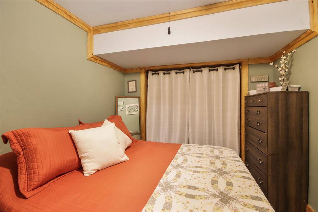 Bedroom downstairs with a closet behind the drapes.