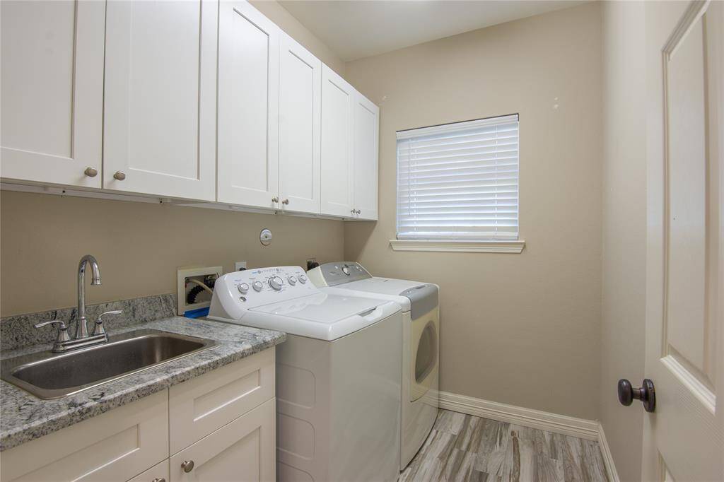 Indoor laundry with a cabinets and sink.