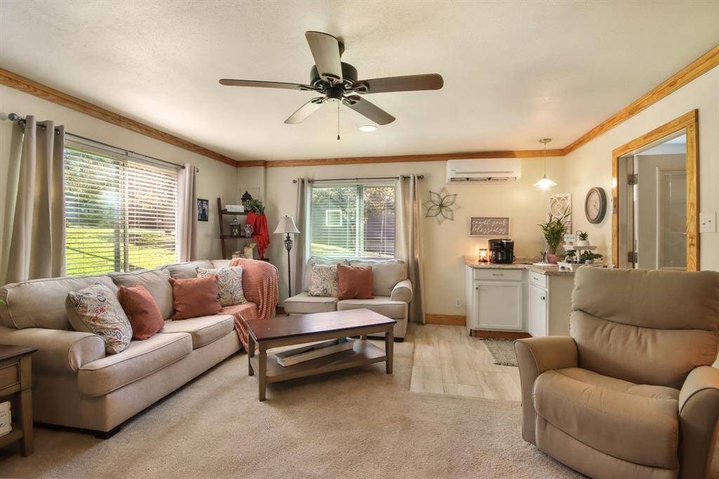 Living room has windows for plentiful natural lighting and a convenient coffee/wet bar.