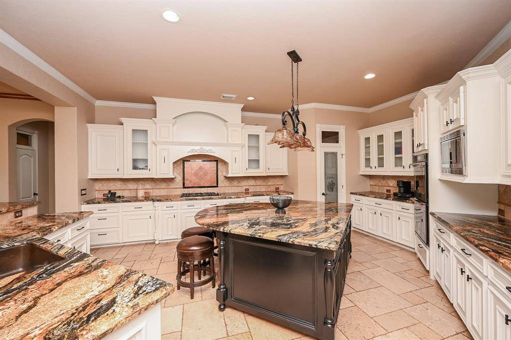 Wow - this is truly a cook's dream with black stainless appliances, 5 burner cook top & tons of storage, as well as a large center island.
