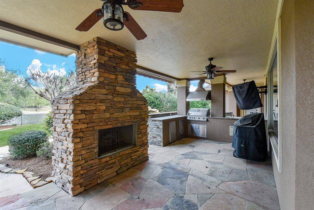 The back patio area is truly another room in the house with a living room section, dining area, outdoor fireplace, and a full outdoor kitchen!